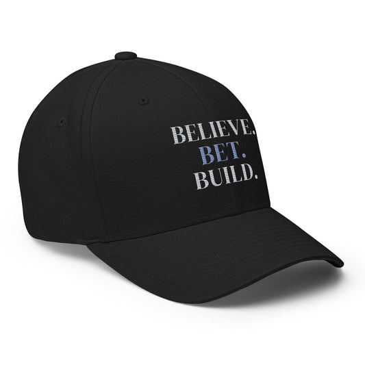 Black Bootstrappin’ BELIEVE. BET. BUILD. Flexfit cap — angled view