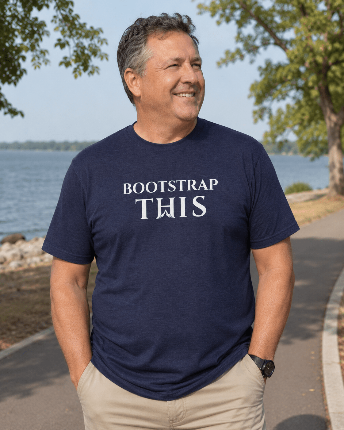 Bootstrap This Men's Tee — White Edition, model wearing the Vintage Black tee outside a storefront.