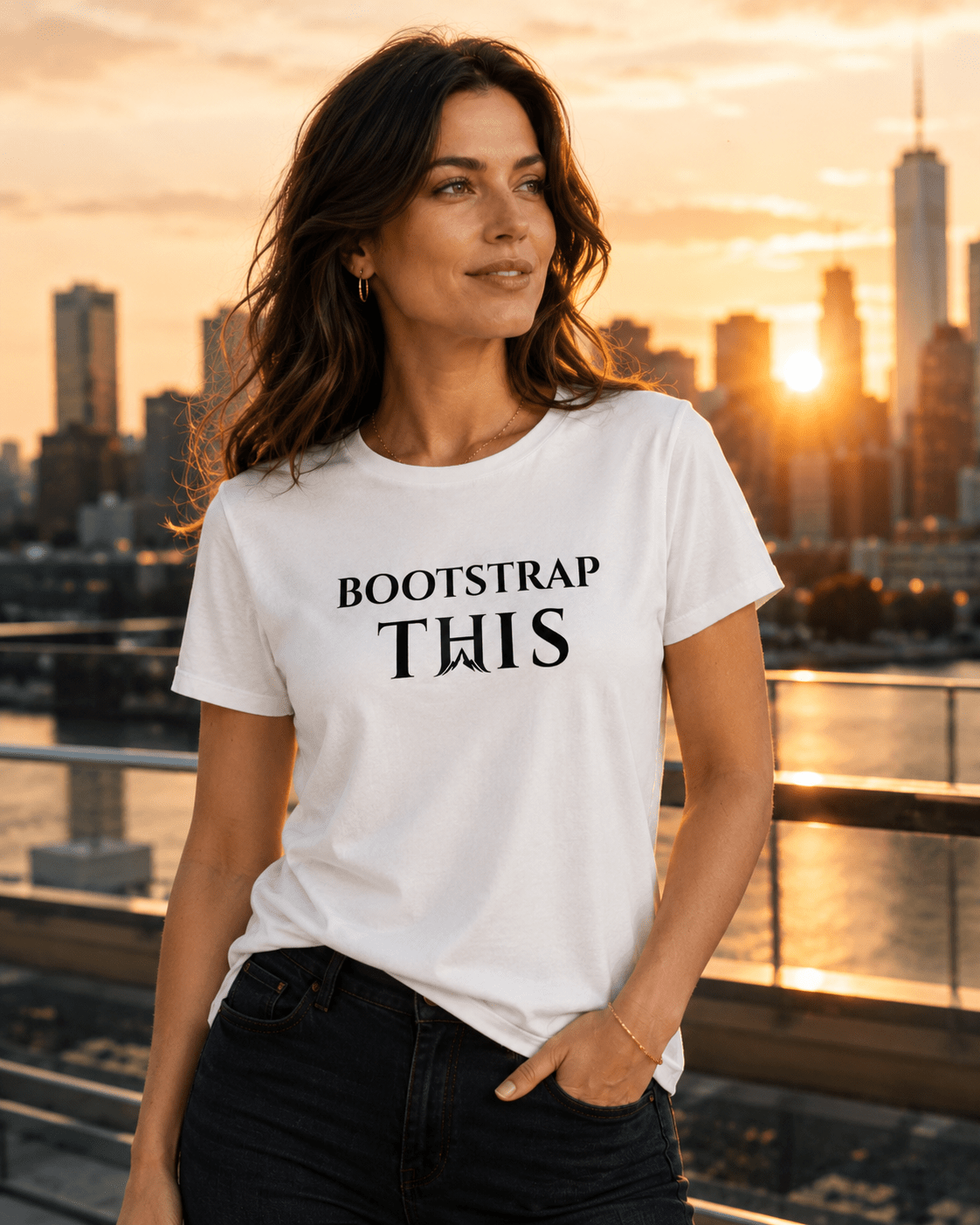Woman wearing the White Bootstrap This Women’s Relaxed Tee with black artwork on a rooftop at sunset