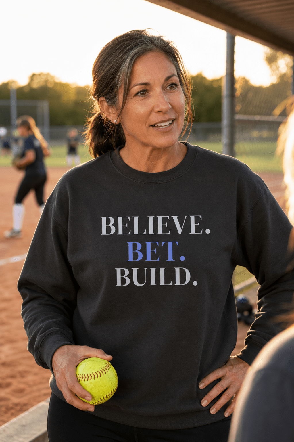 Black Bootstrappin’ BELIEVE. BET. BUILD. crewneck — model holding a tennis ball