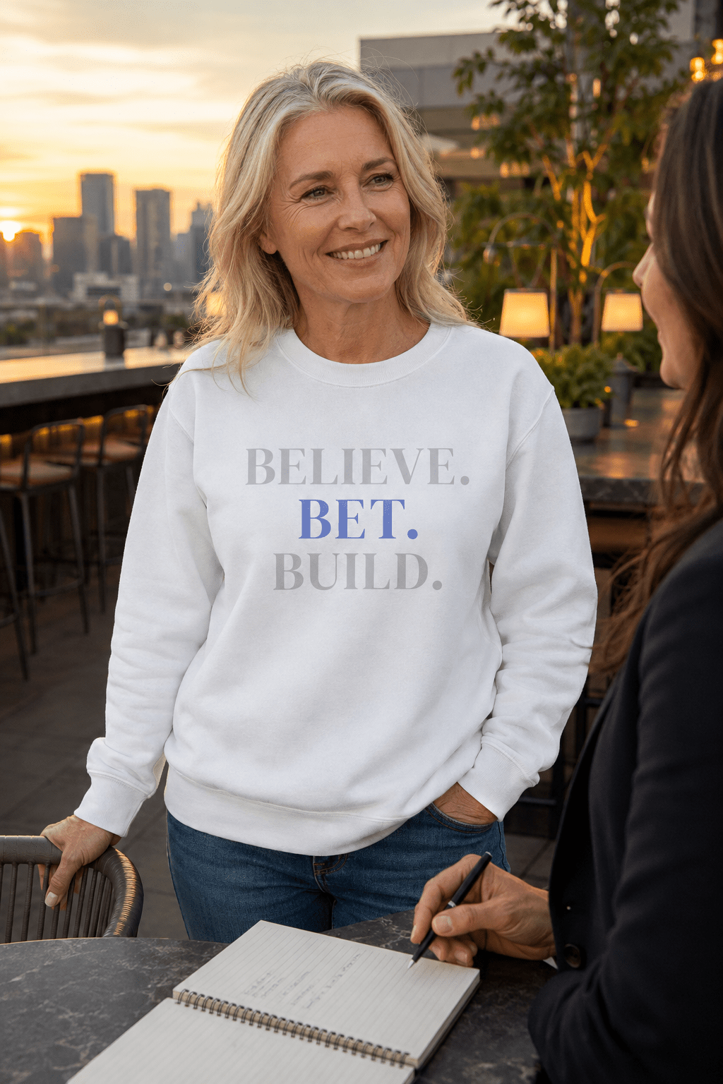White Bootstrappin’ BELIEVE. BET. BUILD. crewneck — model outdoors