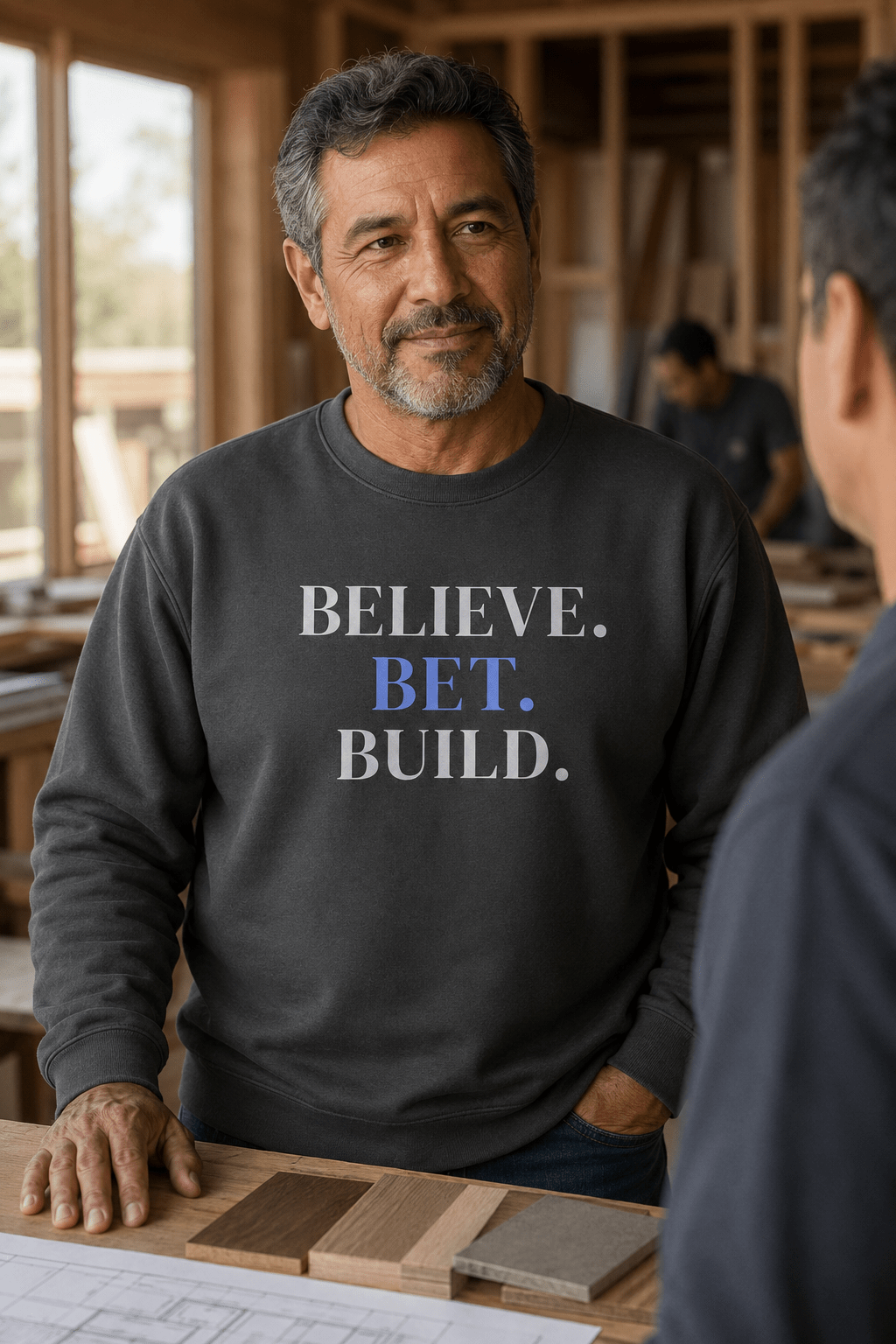 Vintage Black Bootstrappin’ BELIEVE. BET. BUILD. crewneck — model in a workshop