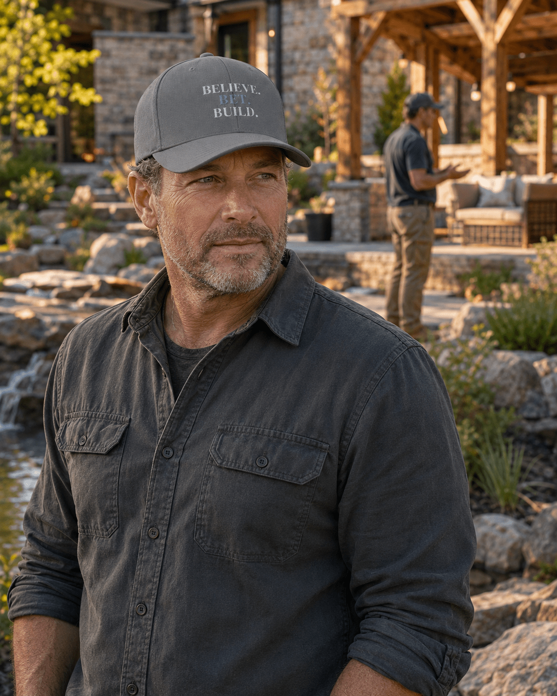 Grey Bootstrappin’ BELIEVE. BET. BUILD. Flexfit cap — model outdoors