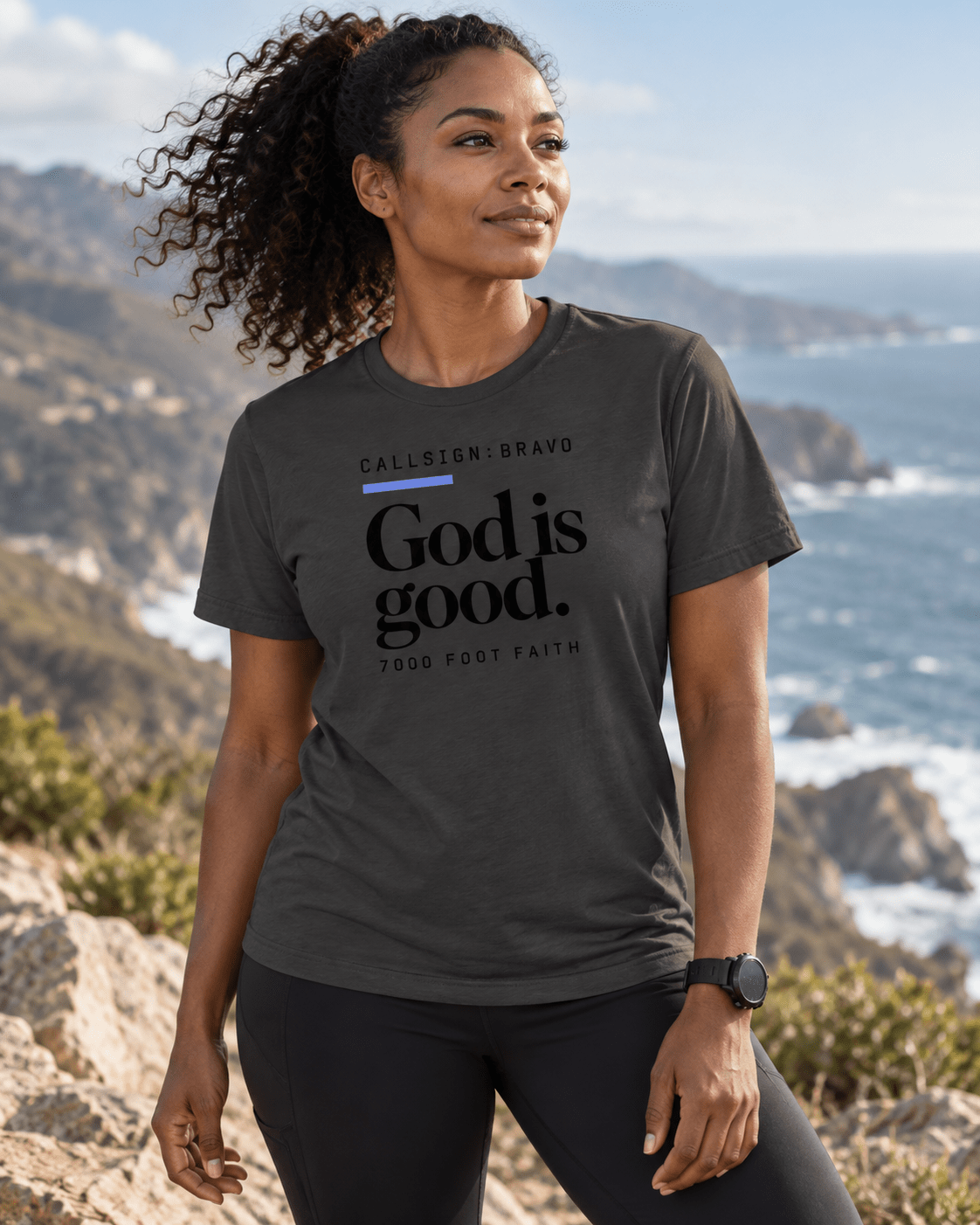 Dark Grey God Is Good CALLSIGN: BRAVO tee — female model by the coast