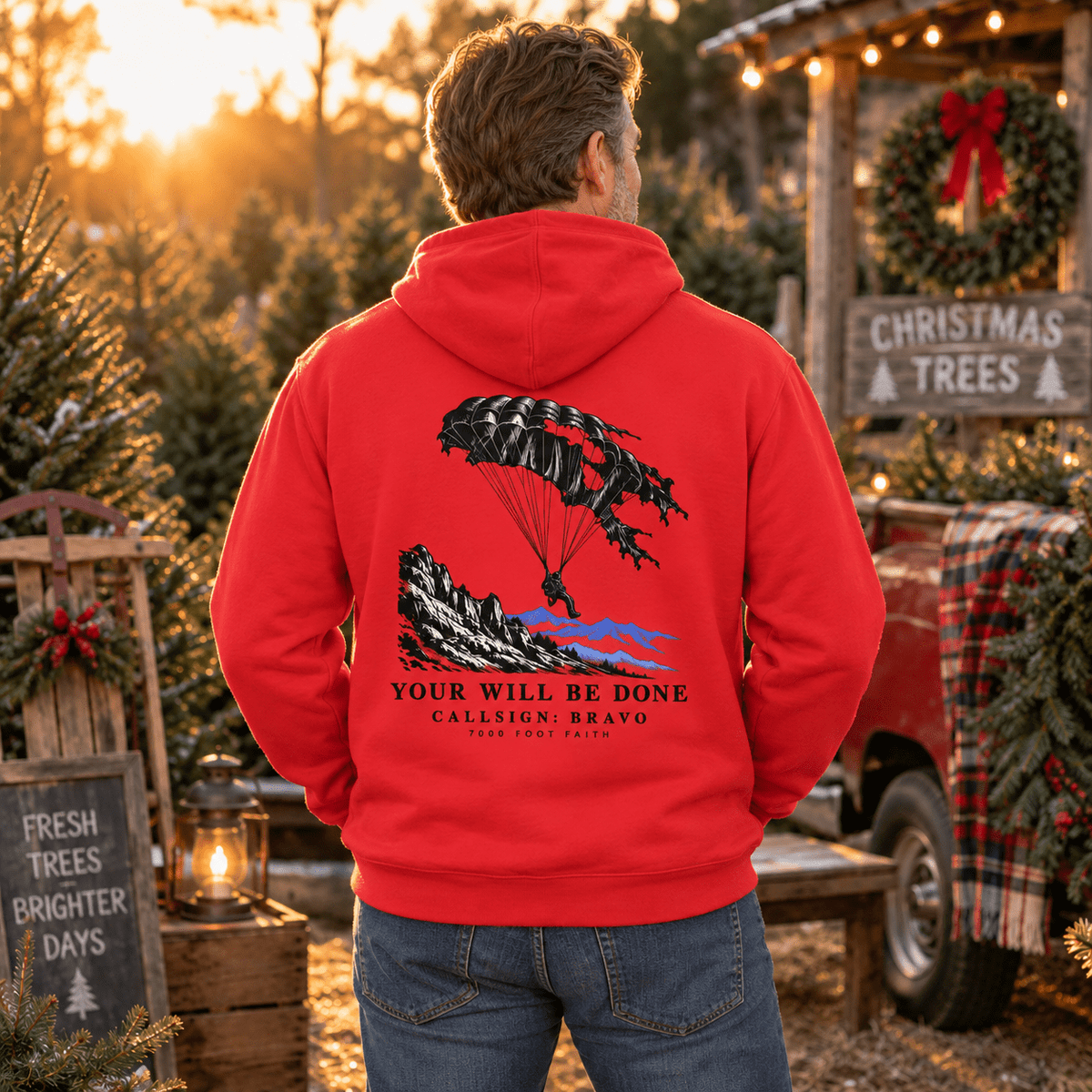 Man wearing a Team Red Your Will Be Done: Descent CALLSIGN: BRAVO hoodie at a Christmas tree lot — back view