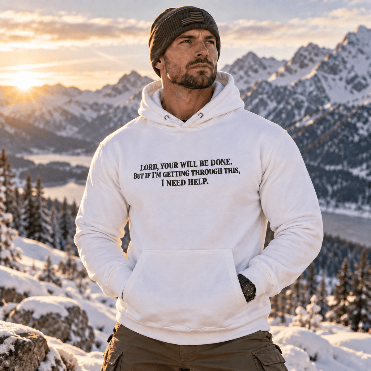 Man wearing a White Your Will Be Done: Descent CALLSIGN: BRAVO hoodie in snowy mountains — front view