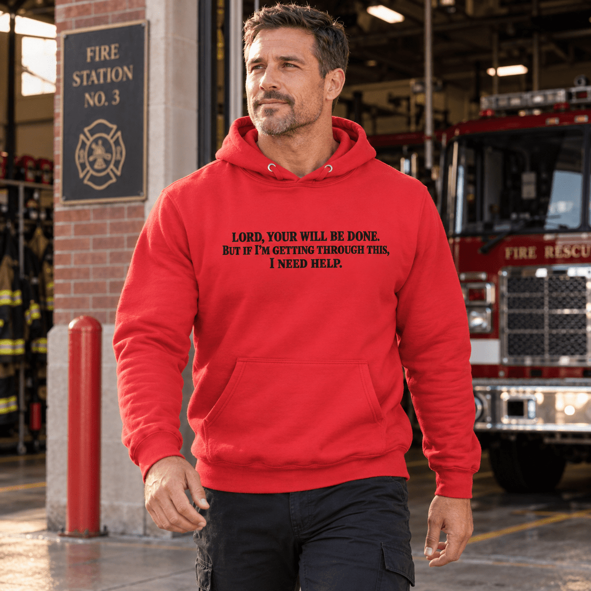 Man wearing a Team Red Your Will Be Done: Descent CALLSIGN: BRAVO hoodie outside a fire station — front view