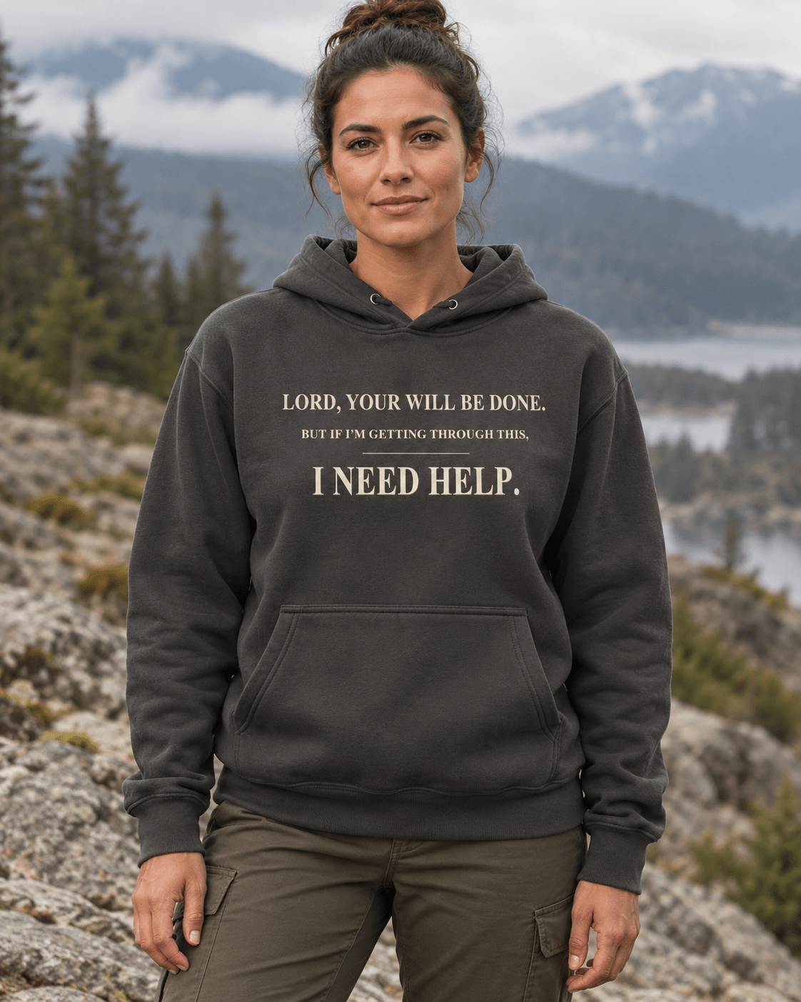 Woman outdoors wearing a Vintage Black DESCENT faith hoodie, front view showing Your Will Be Done and I Need Help lettering