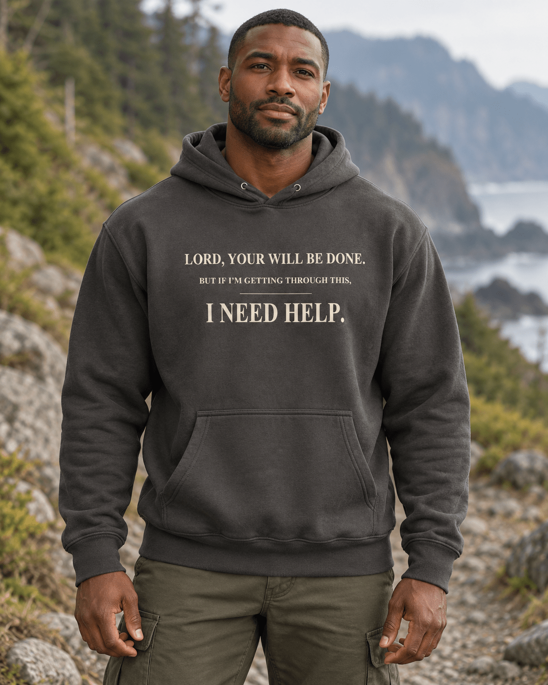 Man outdoors wearing a Vintage Black DESCENT faith hoodie, front view showing Your Will Be Done and I Need Help lettering
